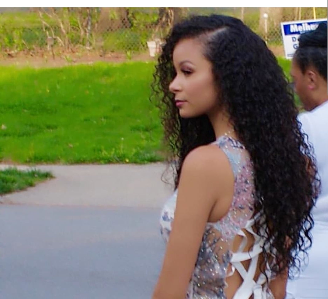 Close-up of Indian Natural Curl hair extension from UltimateHairWorld showcasing rich, full curls with a natural shine.